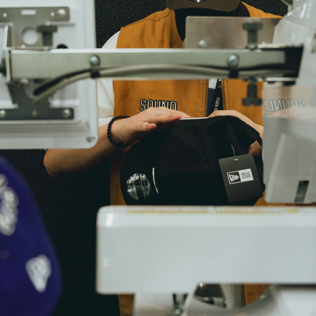 Gorra negra colocada en la máquina bordadora del taller